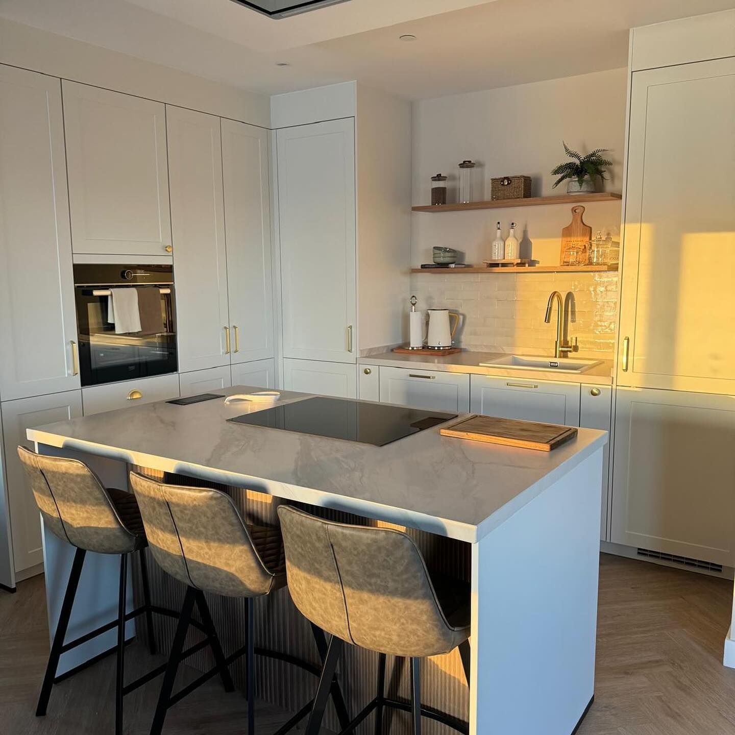 Una cocina con una gran isla y taburetes.