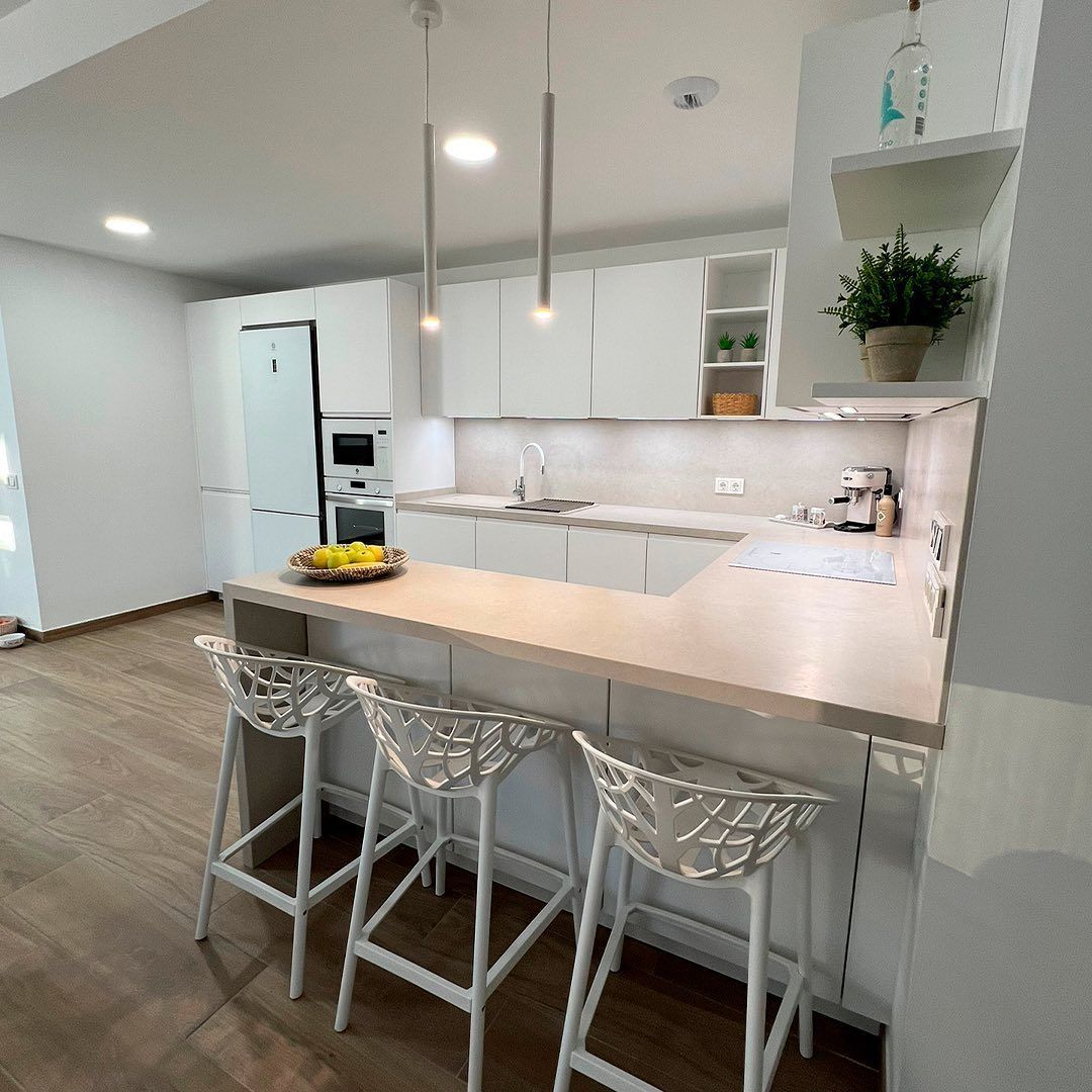 Una cocina con barra y taburetes.