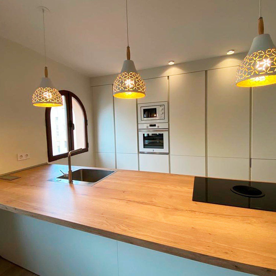 Una cocina con encimera de madera, fregadero y horno.
