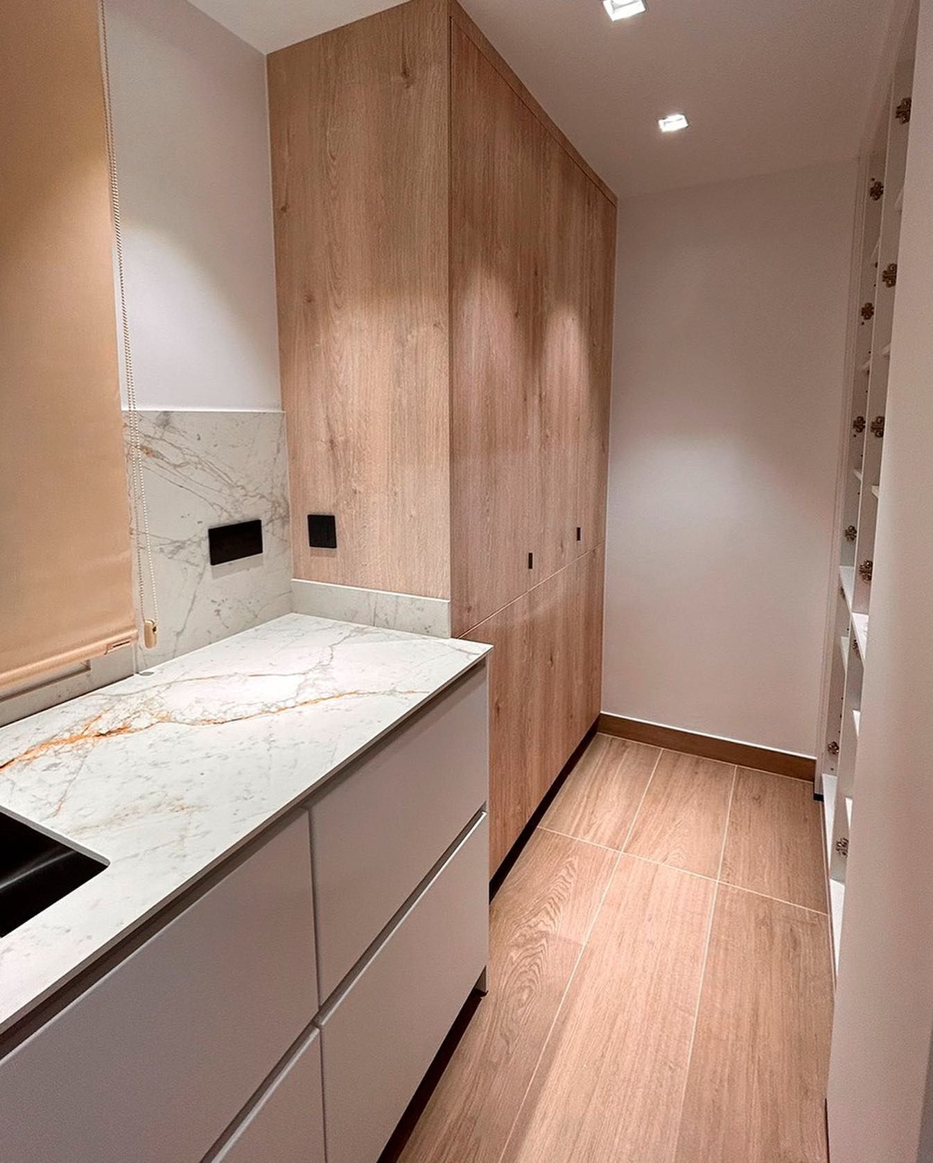 Una cocina con encimeras de mármol y gabinetes de madera.