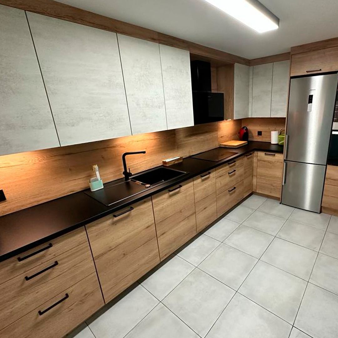 Una cocina con gabinetes de madera y un refrigerador de acero inoxidable.