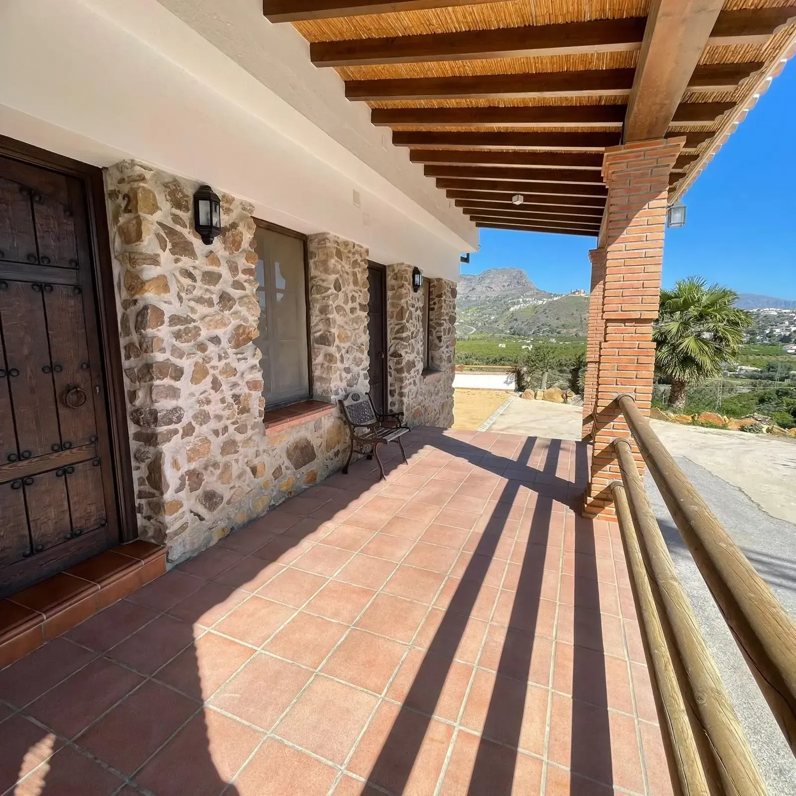 Un edificio de piedra con balcón y barandilla de madera.