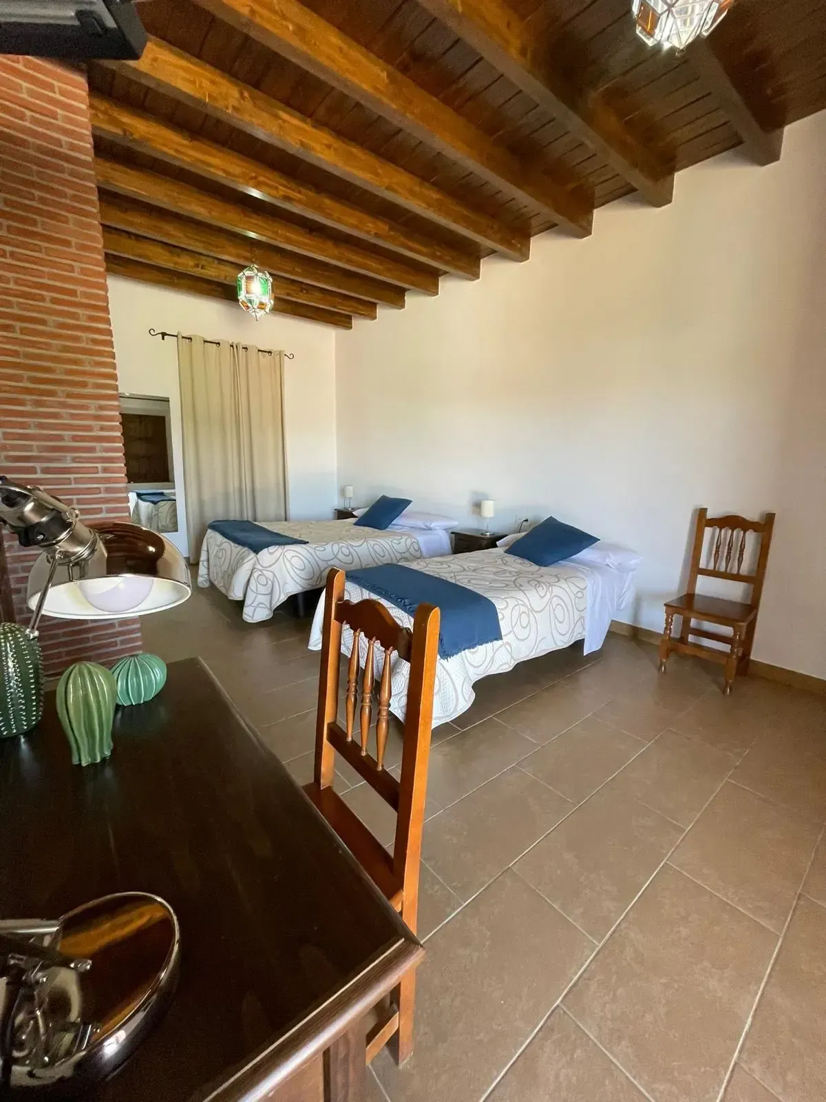 Un dormitorio con dos camas, una mesa, sillas y un lavabo.