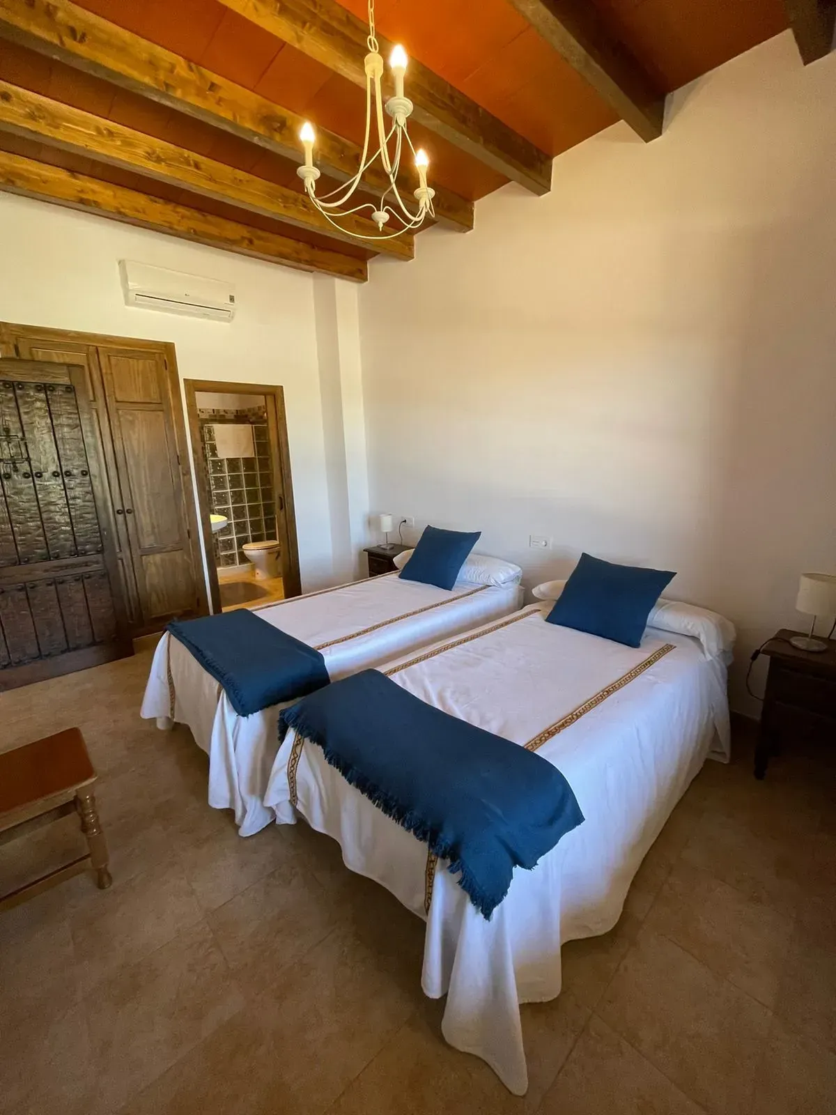 Un dormitorio con dos camas y una lámpara de araña colgando del techo.