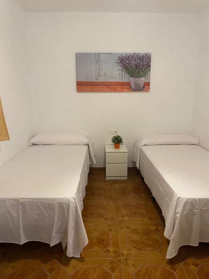 Un dormitorio con dos camas, una mesita de noche y un cuadro en la pared.