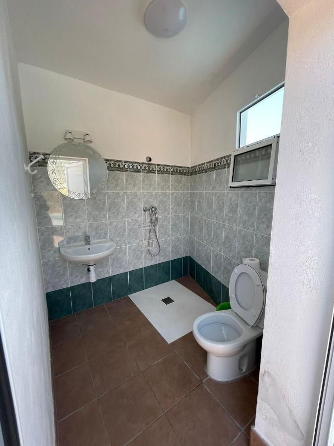 Un baño con inodoro, lavabo y espejo.