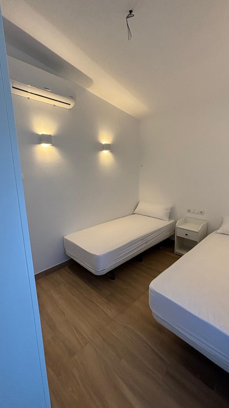 Un dormitorio con dos camas y una mesita de noche.