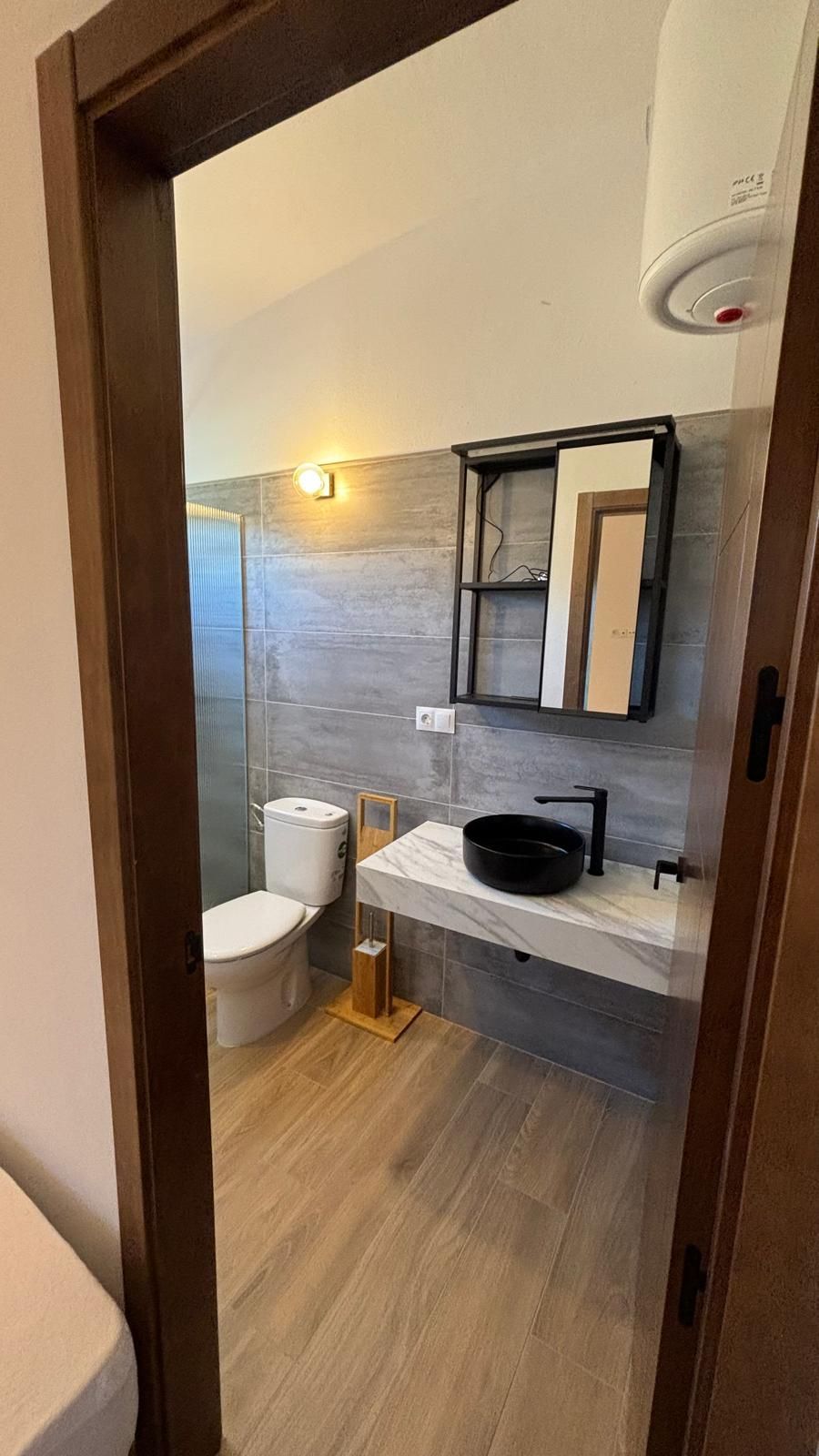 Un baño con inodoro, lavabo y espejo.