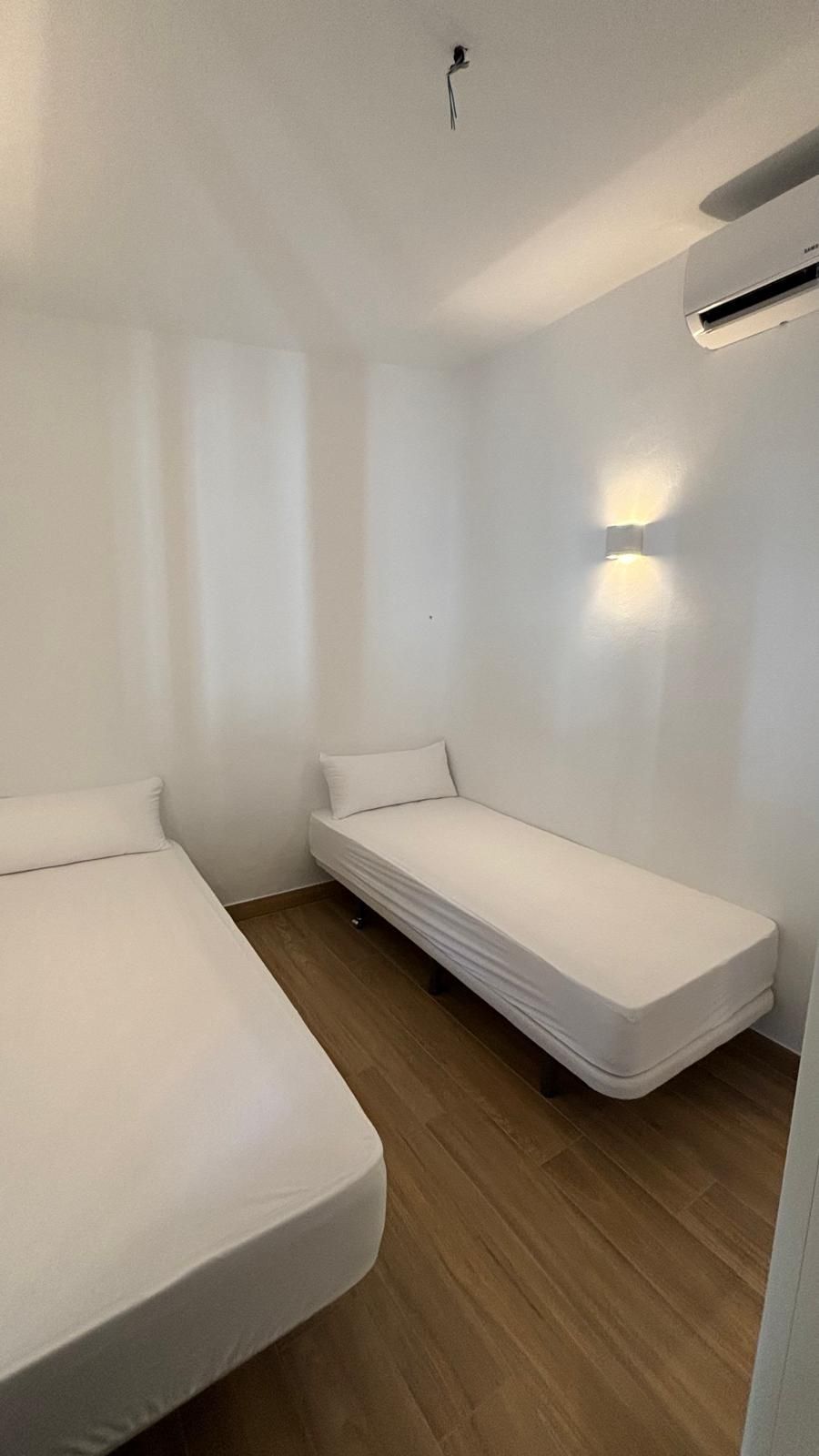 Un dormitorio con dos camas y aire acondicionado.