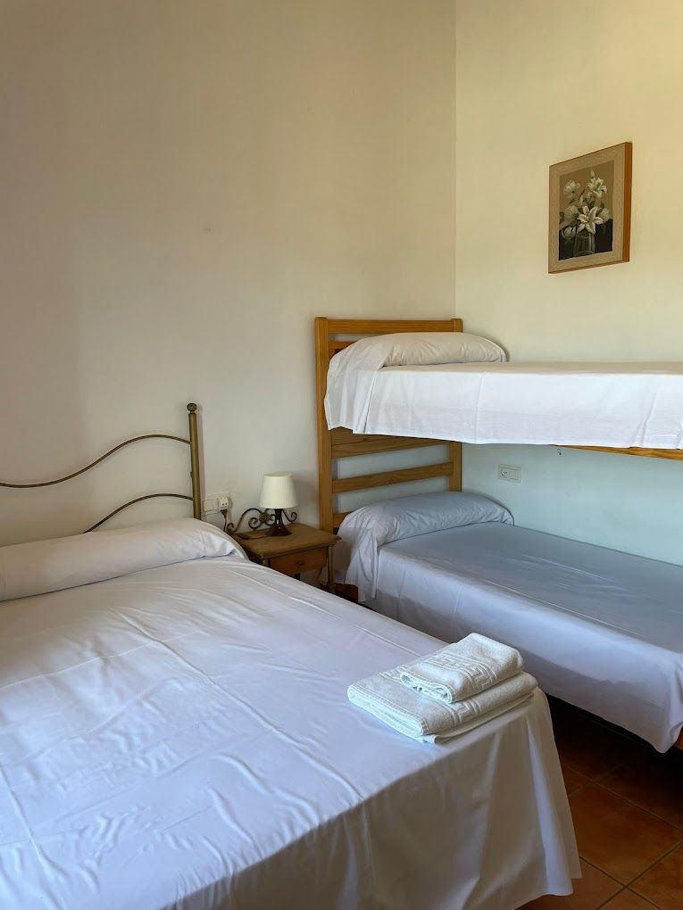 Un dormitorio con dos camas y una litera.