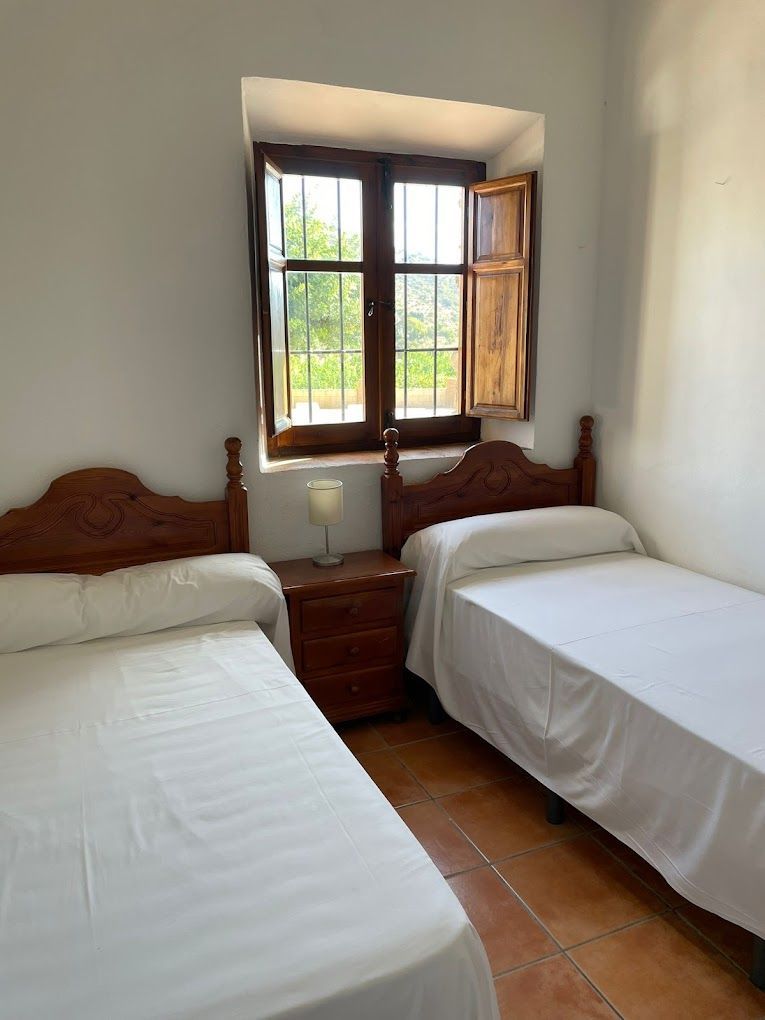 Un dormitorio con dos camas y una ventana.