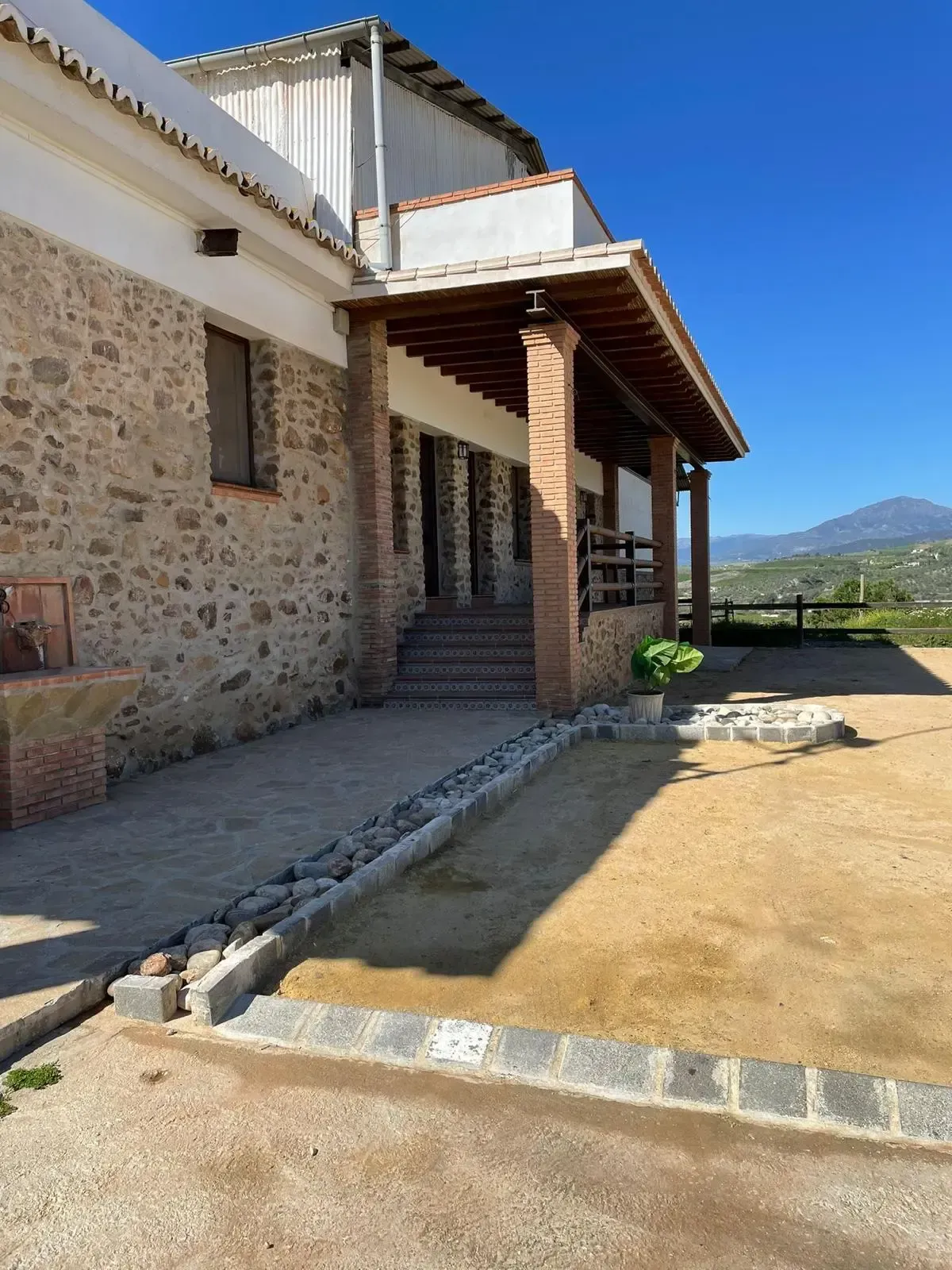 Un gran edificio de piedra con porche y escaleras.