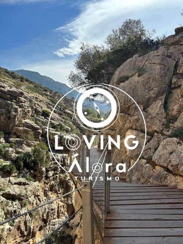 Un puente de madera que conduce a una montaña cubierta de rocas.