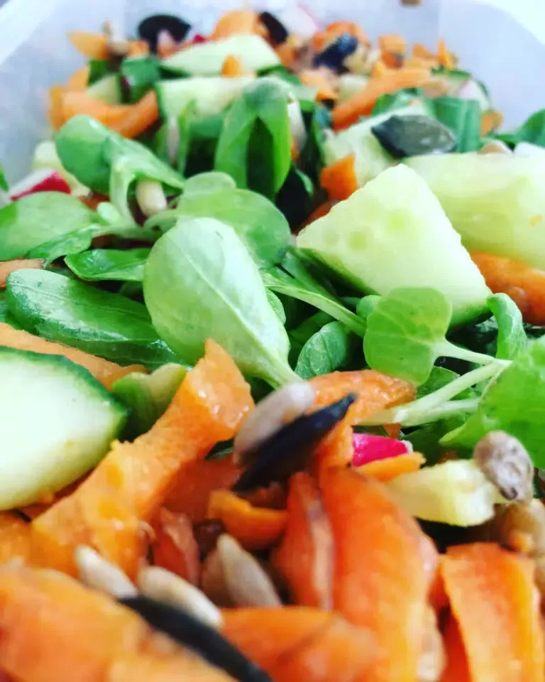 Eine Nahaufnahme von einem Salat mit Karotten und Gurken