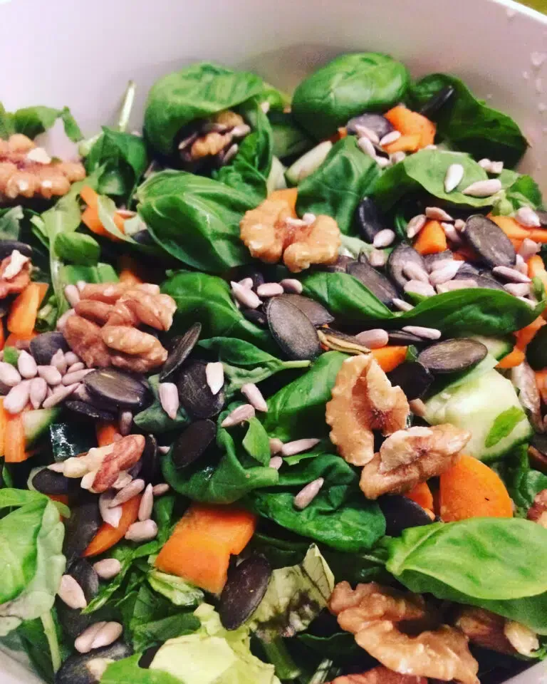 Ein Salat mit Spinat Karotten Walnüssen und Sonnenblumenkernen