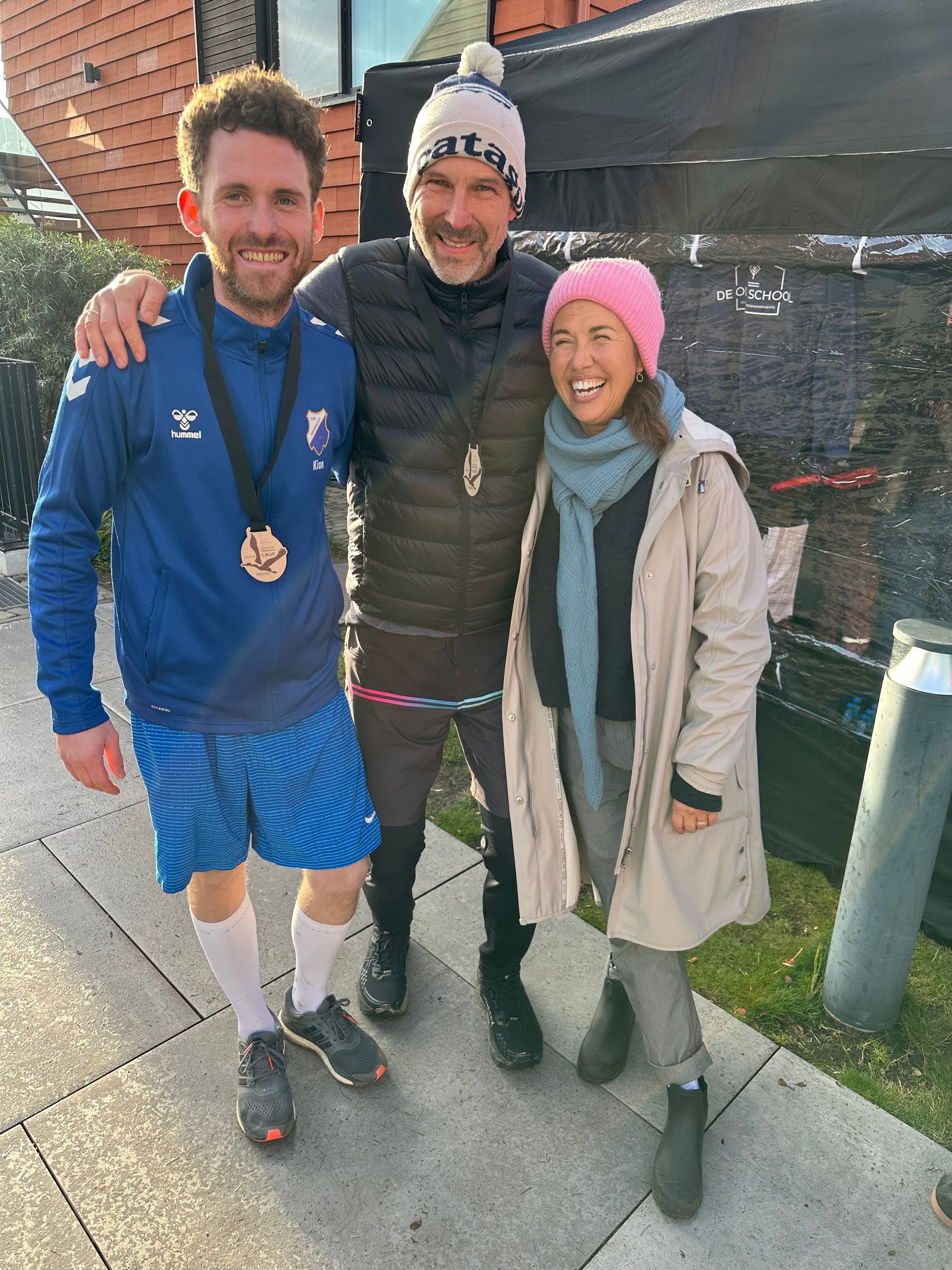 Eine Reihe von Häusern mit roten Ziegeldächern stehen nebeneinander in einer Kopfsteinpflasterstraße.