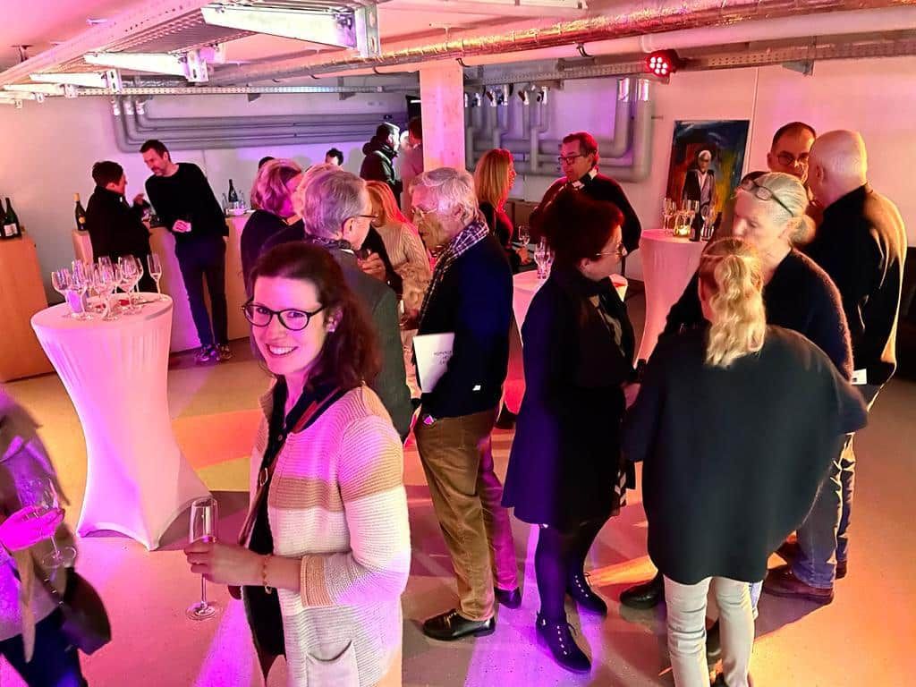 Eine Gruppe von Leuten steht in einem Raum mit violettem Licht.