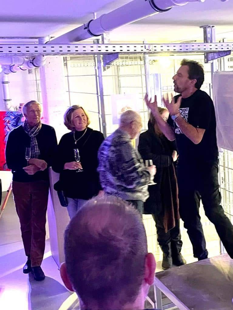 Eine Gruppe von Leuten steht in einem Raum und unterhält sich.