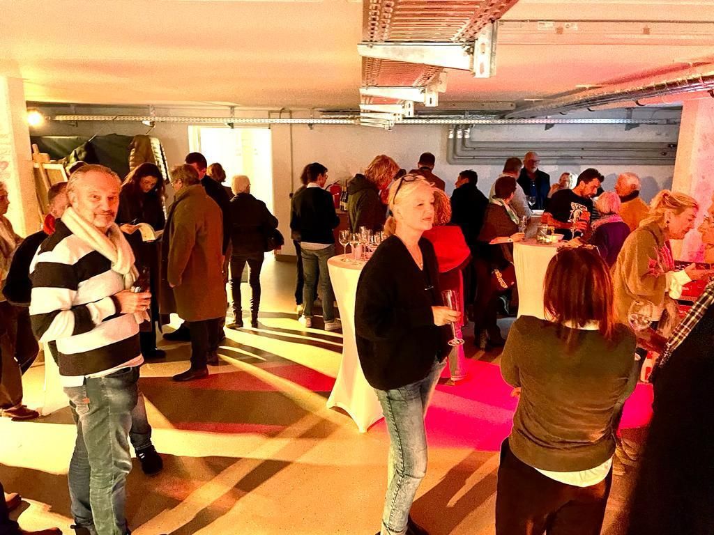 Eine Gruppe von Menschen steht in einem Raum um Tische herum