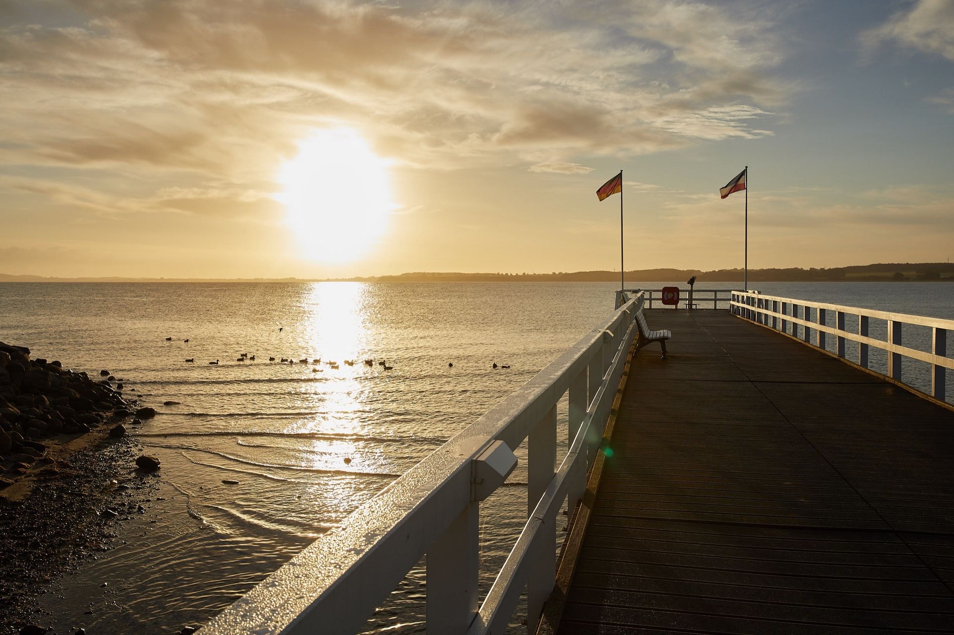 Ein Pier mit Blick auf ein Gewässer bei Sonnenuntergang