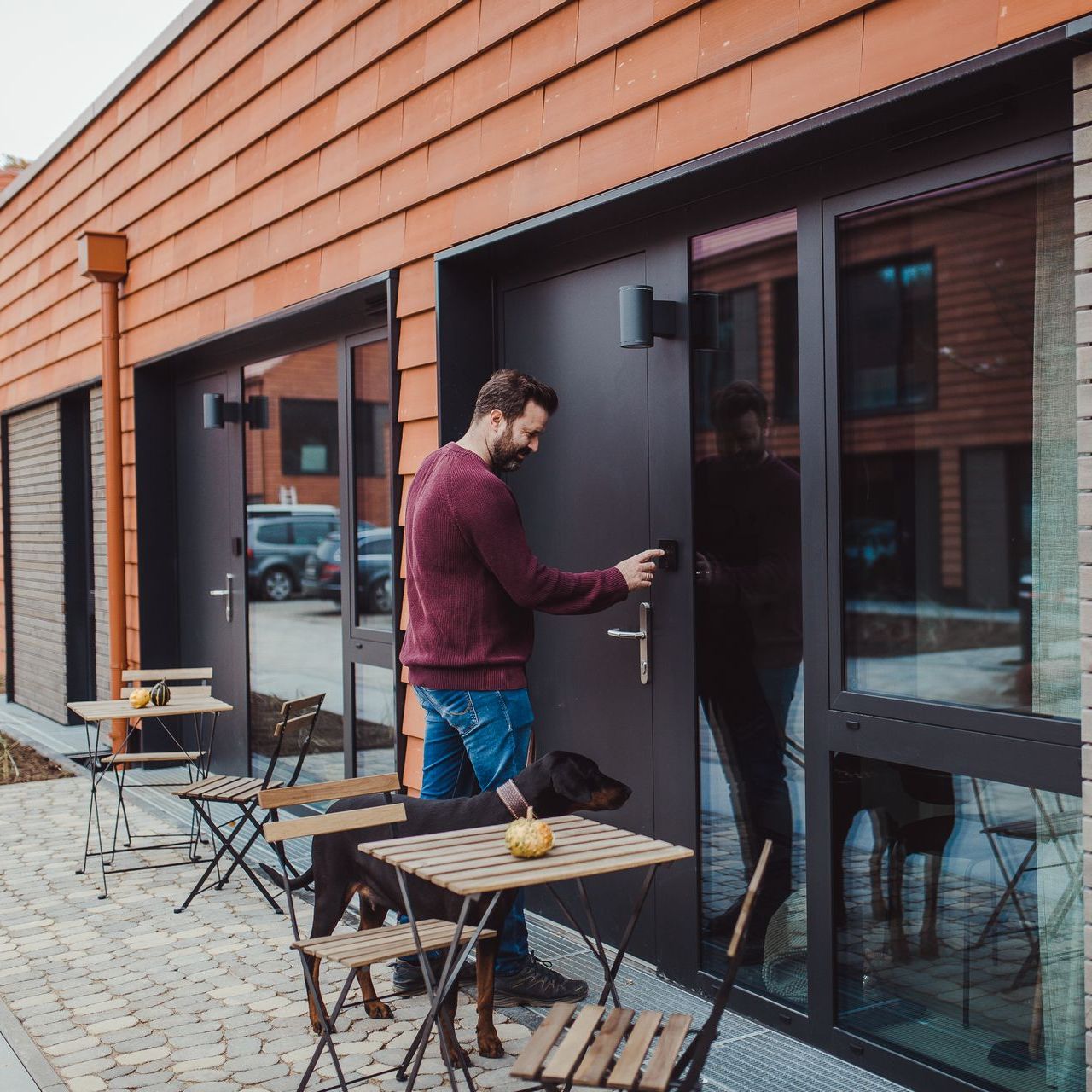 A man and his dog are standing outside of a building