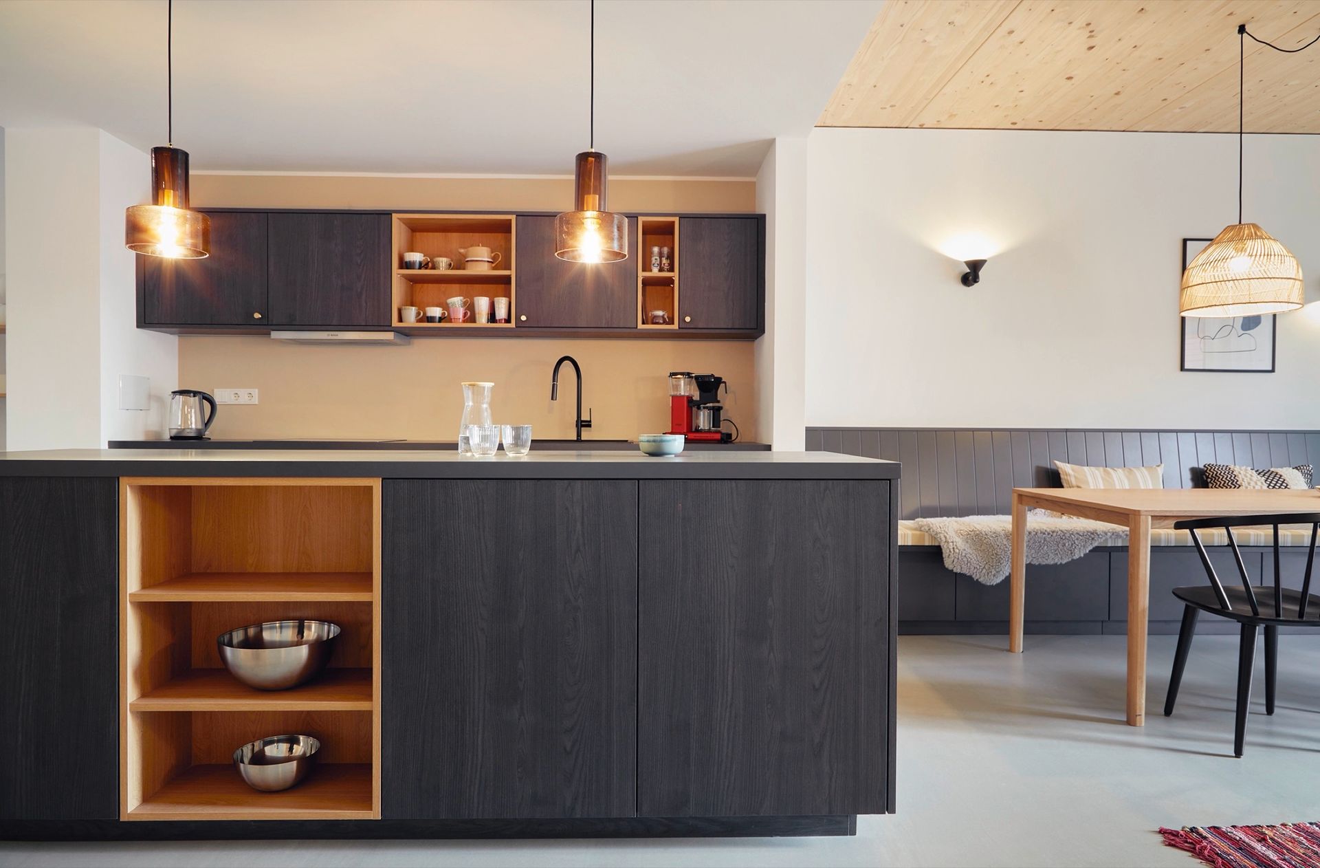 Eine Küche mit schwarzen Schränken und Holzregalen