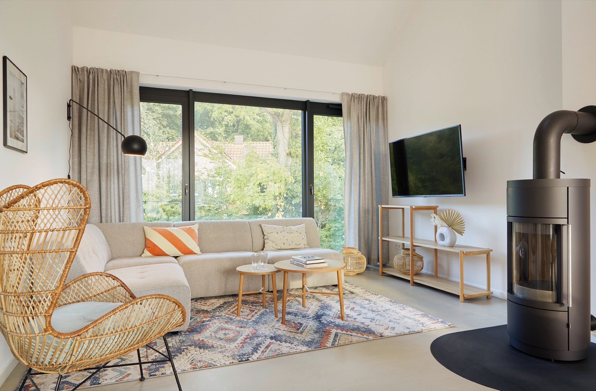 Ein Wohnzimmer mit Couch, Sessel, Fernseher und Kamin.