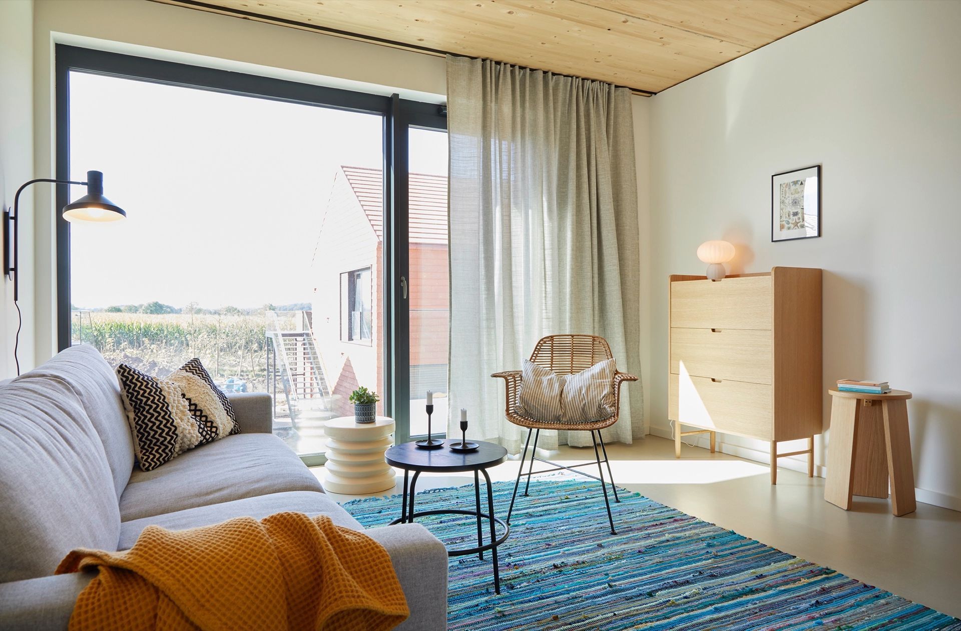 Ein Wohnzimmer mit Couch, Sessel, Tisch und Teppich.