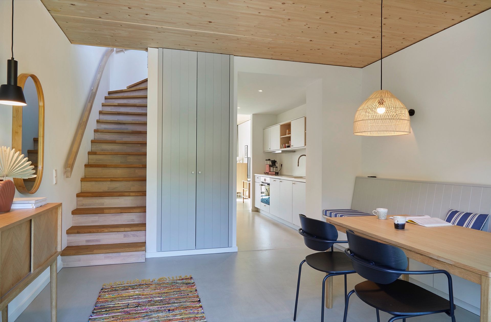 Ein Wohnzimmer mit Tisch und Stühlen und Treppe in einer Ferienwohnung in Hohwacht.