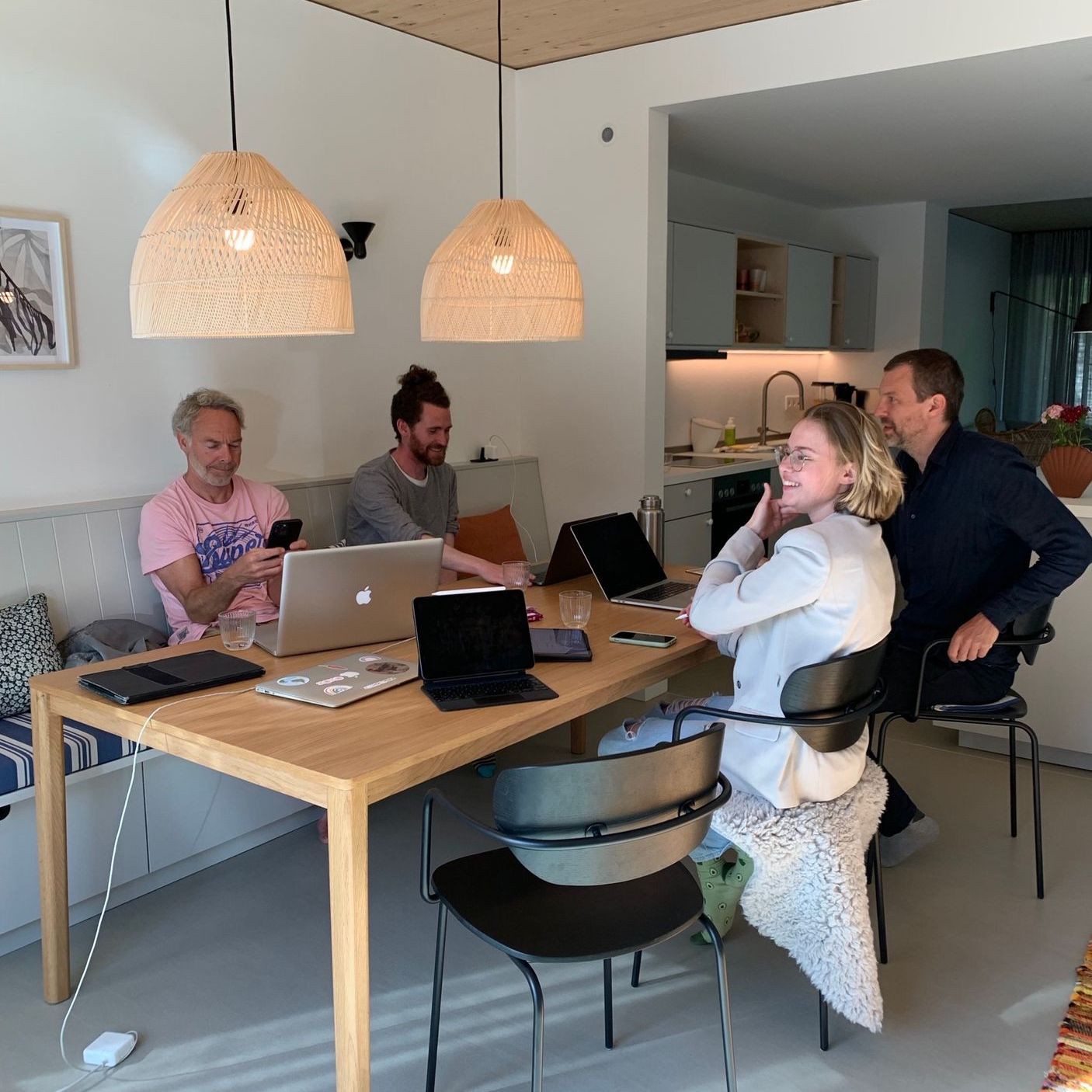 A group of people are sitting at a table with laptops