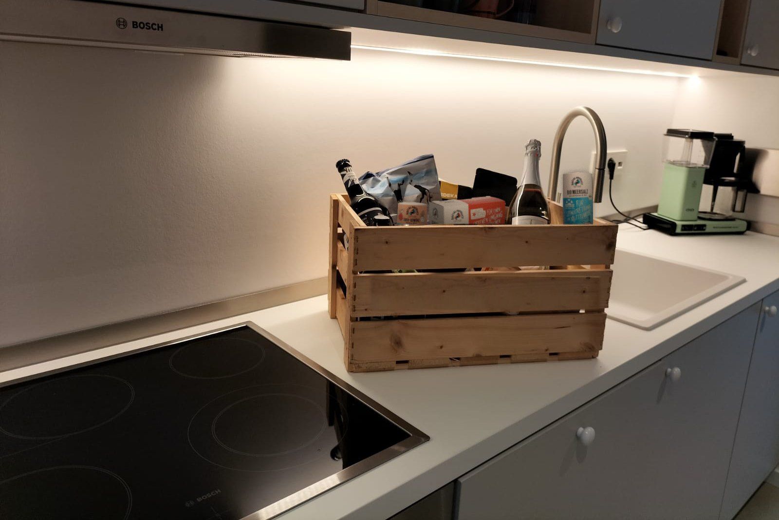 Bio-Box von De ole School in der Apartmentküche mit regionalen Lebensmitteln, Wein und Produkten von social product