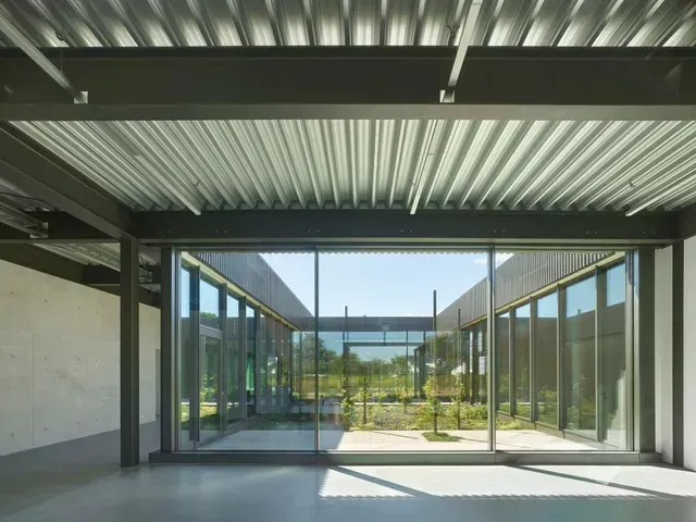 Ein großer Raum mit vielen Fenstern und einer Metalldecke.