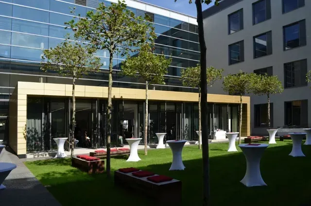 Ein Gebäude mit vielen Fenstern und Tischen davor