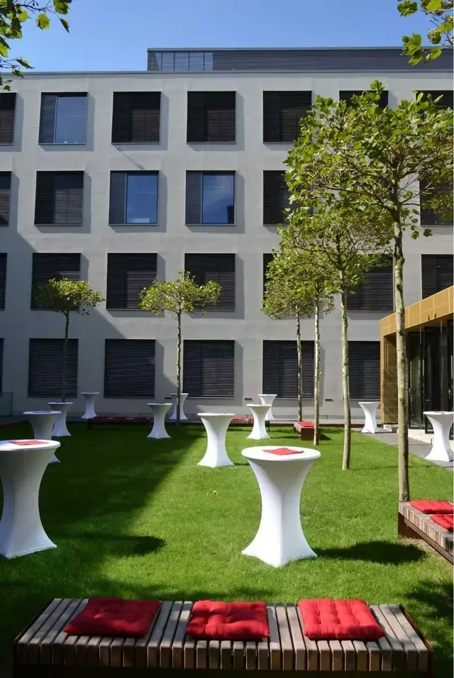 Eine Rasenfläche mit Tischen und Bänken vor der Physikalischen Institute der Universität Heidelberg im Neuenheimer Feld