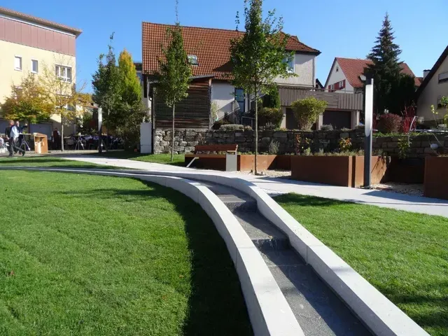 Eine Rasenfläche mit einem Brunnen beim Grüner Anger Plüderhausen