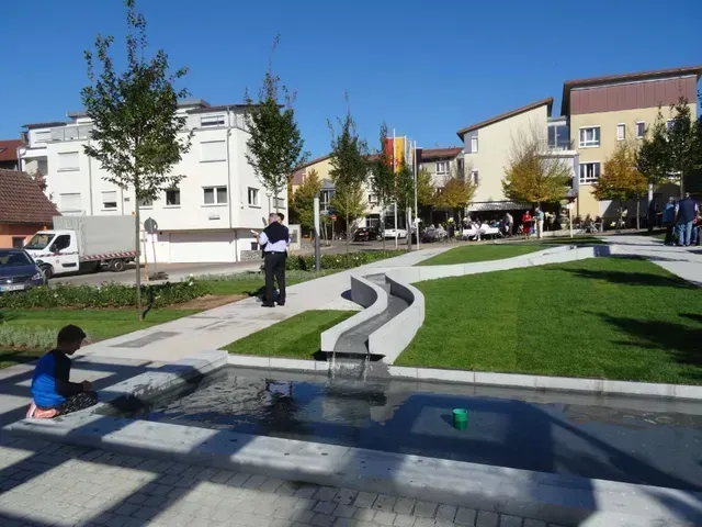 Eine Rasenfläche mit einem Brunnen beim Grüner Anger Plüderhausen