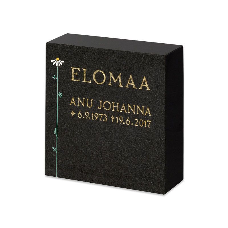 Mustasta graniitista tehty muistolaatta, jossa kultaiset tekstit ”ELOMAA” ja ”ANU JOHANNA” sekä vuosiluvut.