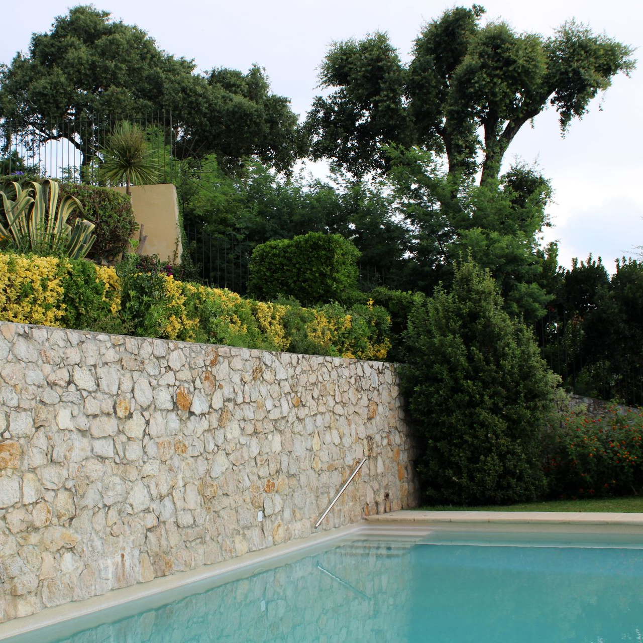 Mur de soutènement d'un jardin avec piscine en dessous.