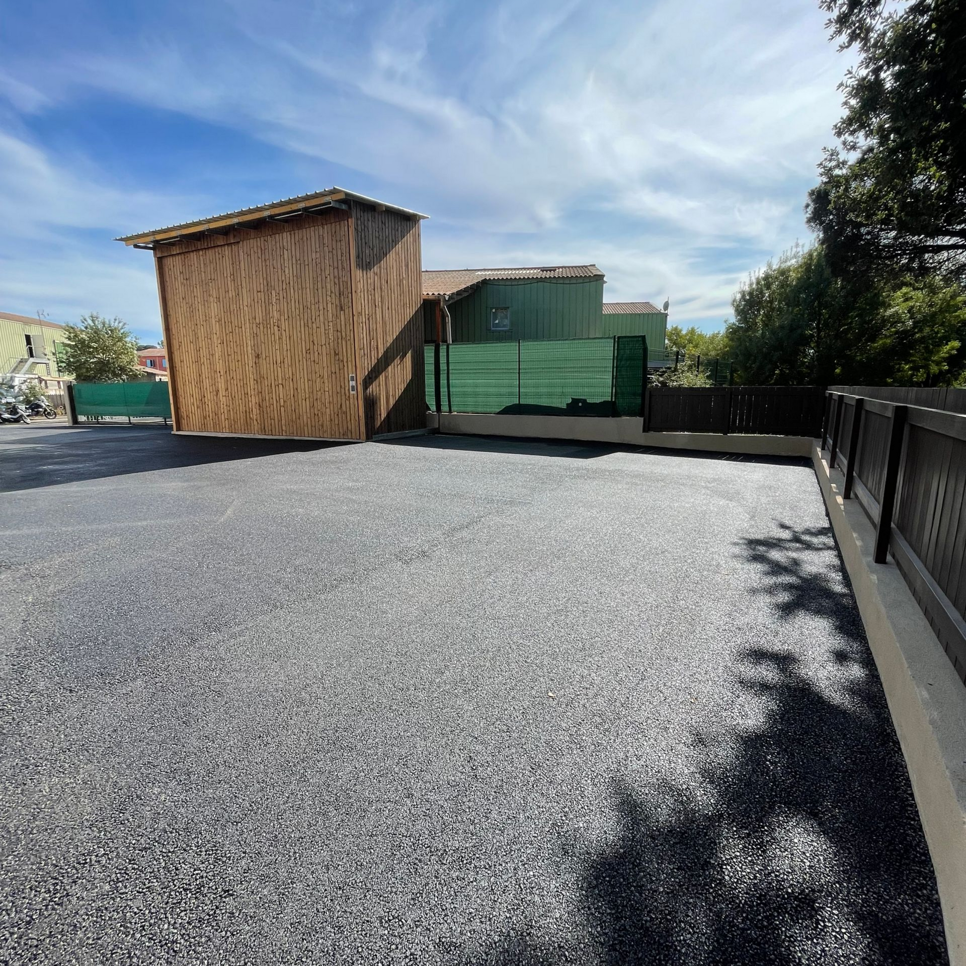 Parking rénové avec un enrobé noir.