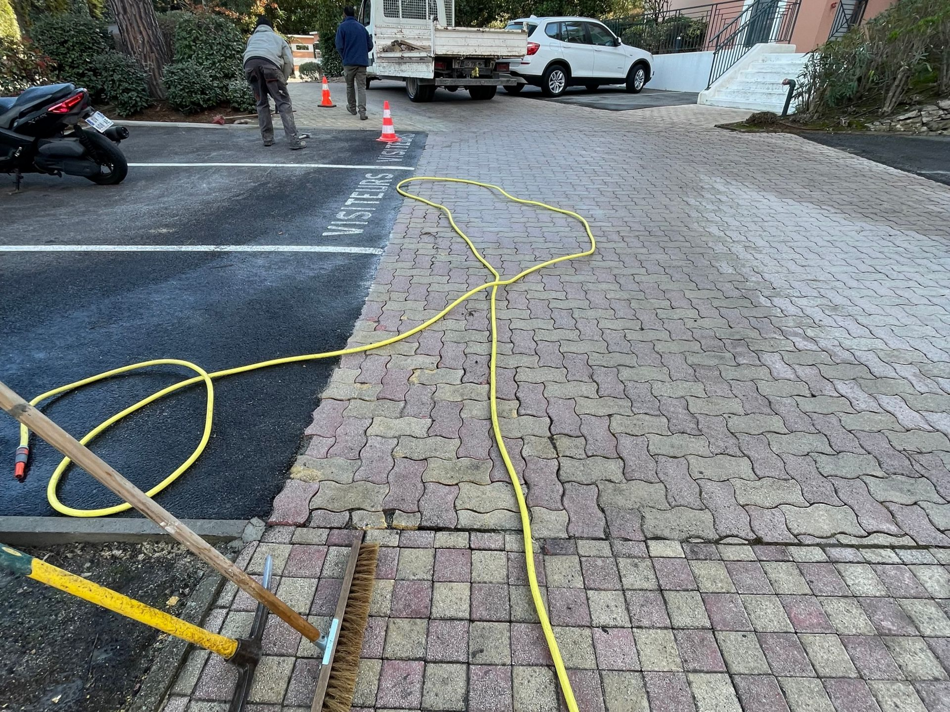 Pavage autour d'un parking devant un bâtiment public.
