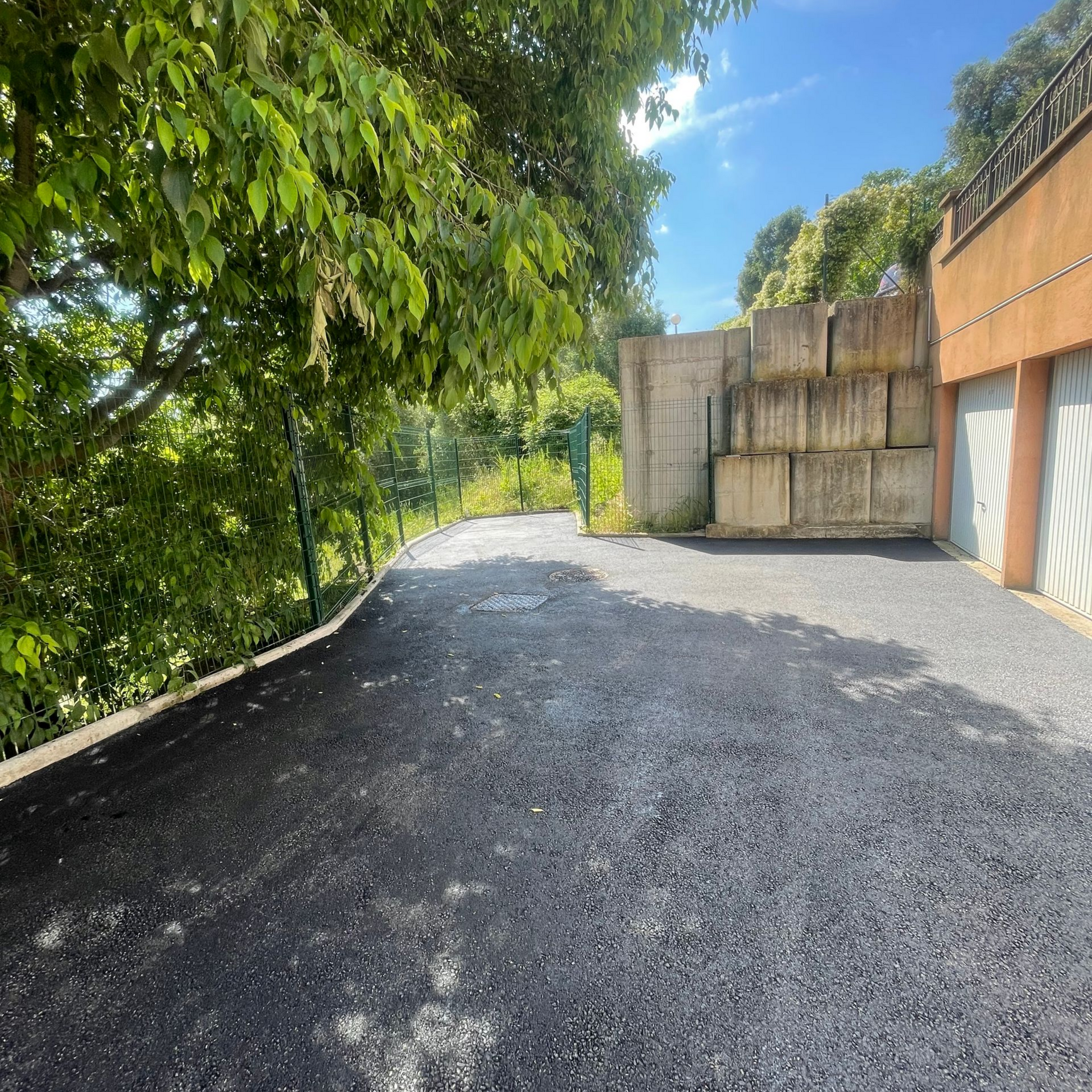 Espace devant des garages recouverts de goudron.