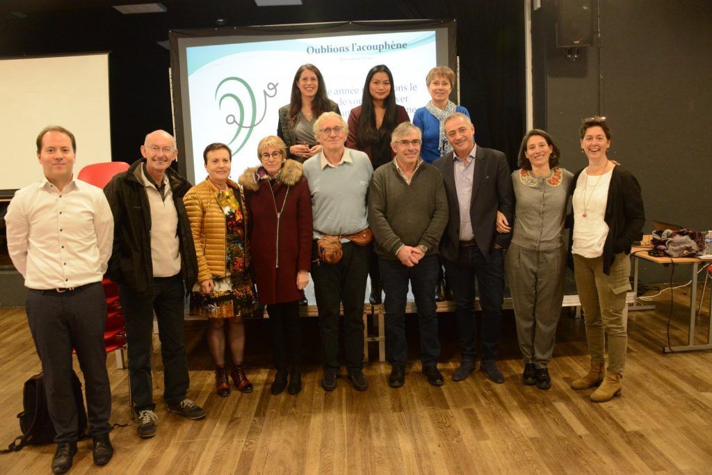 Groupe de personnes debout devant un écran, probablement lors d'une présentation.