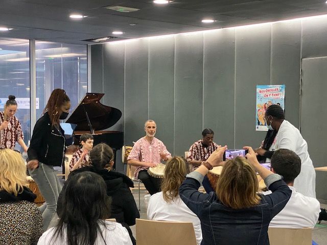 Des gens qui jouent du tambour et dansent, avec un piano dans une pièce.