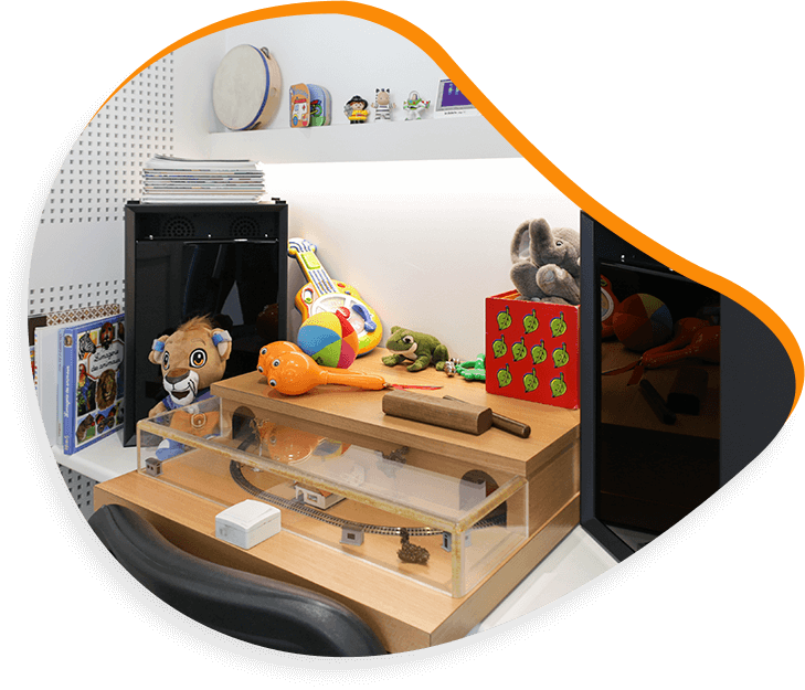 Des jouets et des objets disposés sur une table en bois, notamment une peluche de lion, une guitare et un bloc à points.