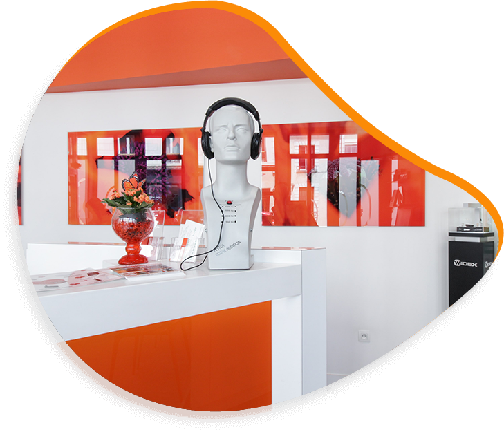 Présentoir dans un magasin à dominante orange, avec un buste portant un casque audio.