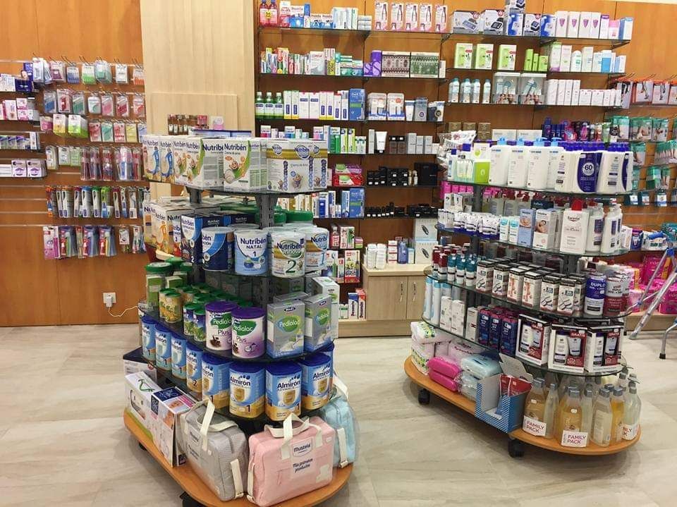 Dos estantes redondos de exhibición llenos de diversos productos de leche de fórmula y productos de higiene para bebés envasados, ubicados dentro de una farmacia.