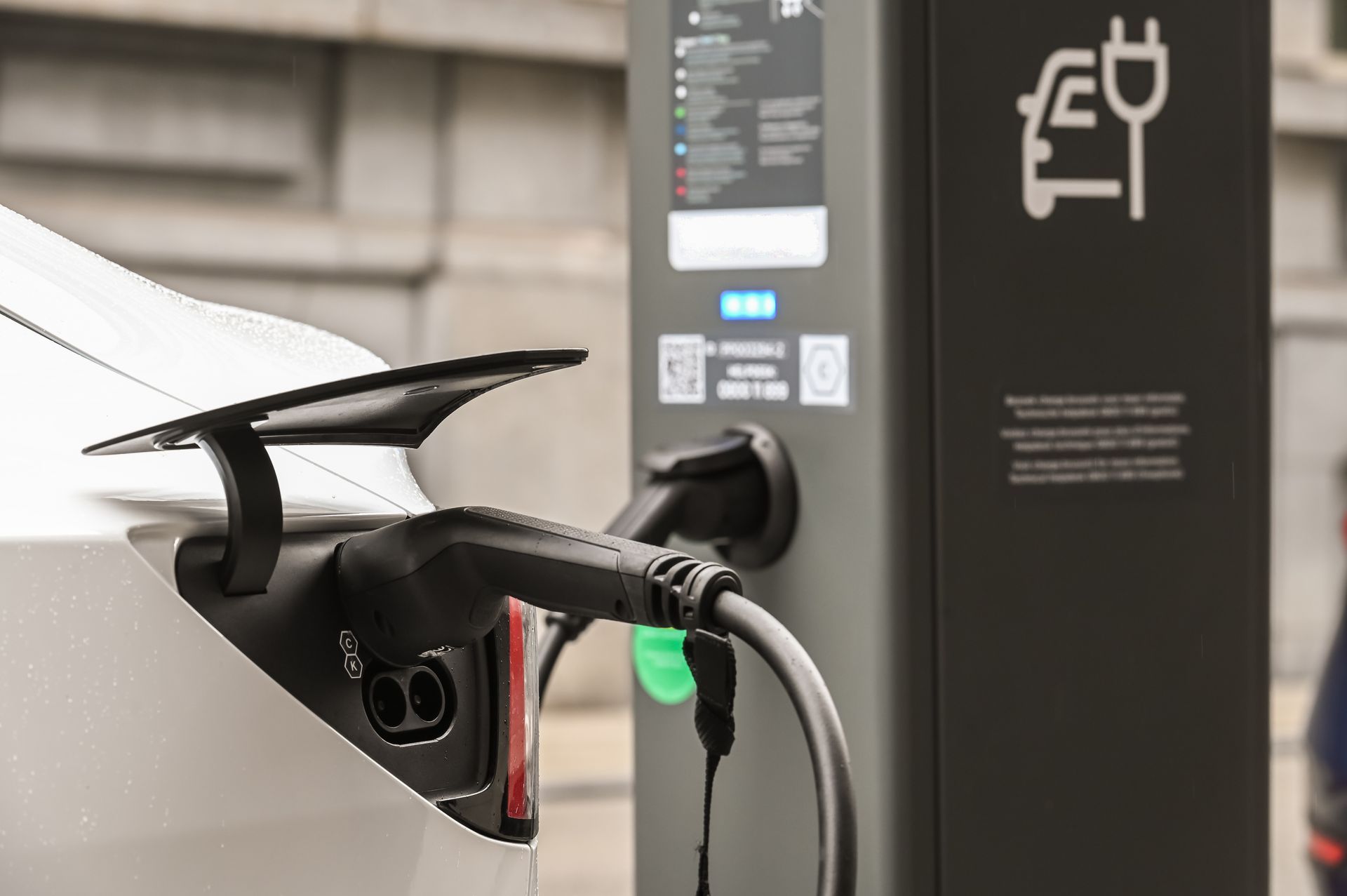 Recharge d’une voiture électrique dans une station, avec un connecteur branché.