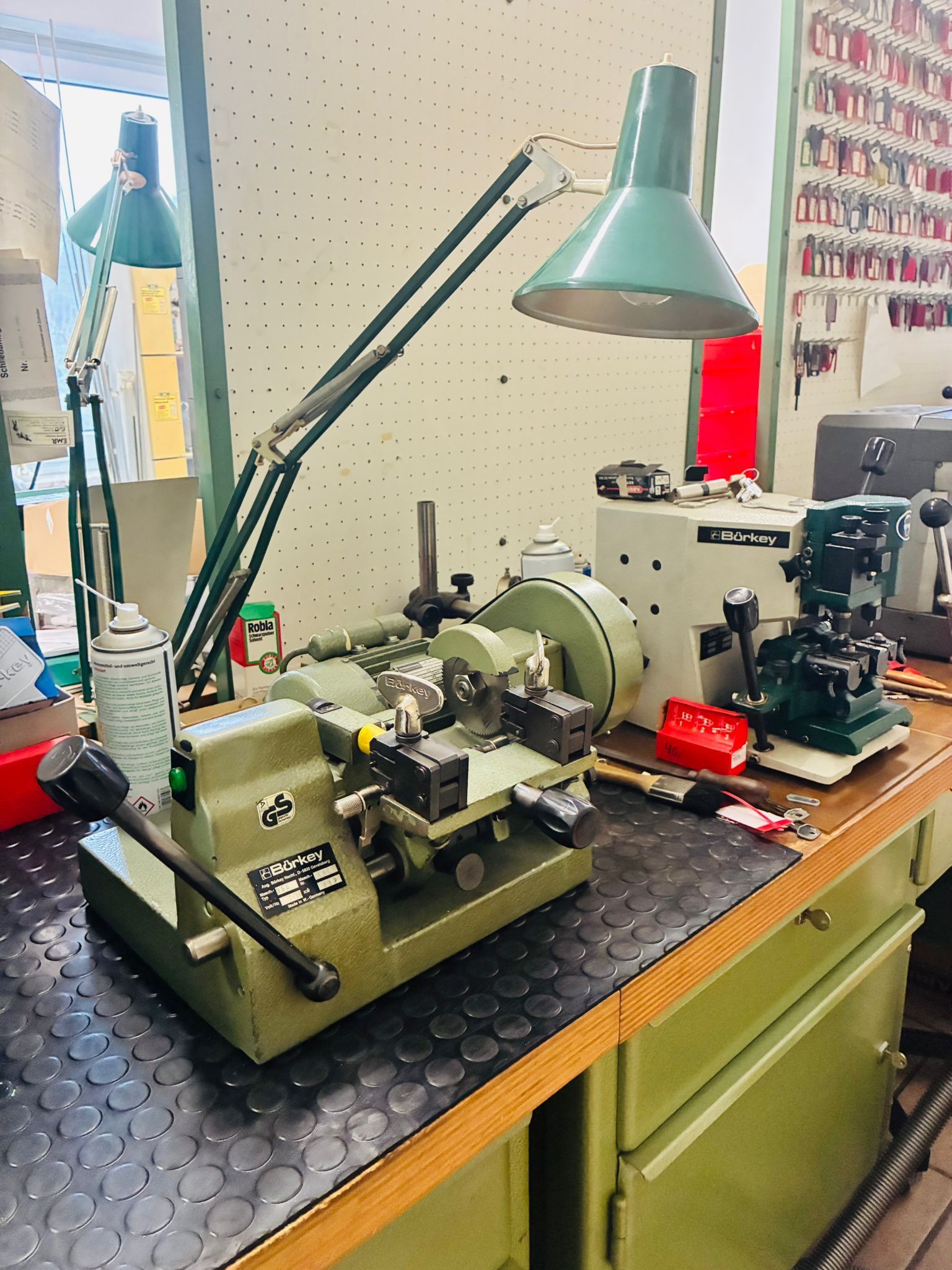 Schlüsselkopiermaschine mit Lampe auf einer Werkbank in einem Schlüsseldienst.