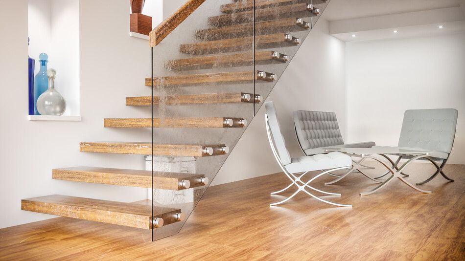 Una escalera de madera con barandilla de cristal en una sala de estar.