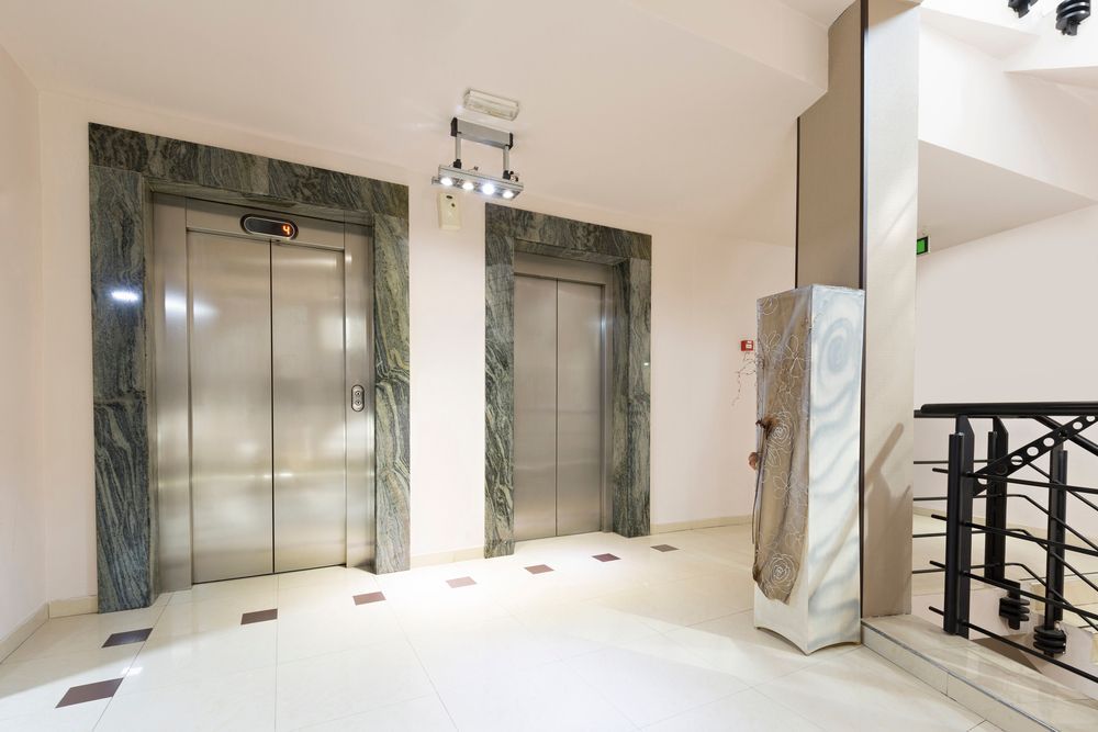 Hay dos ascensores en el pasillo de un edificio.